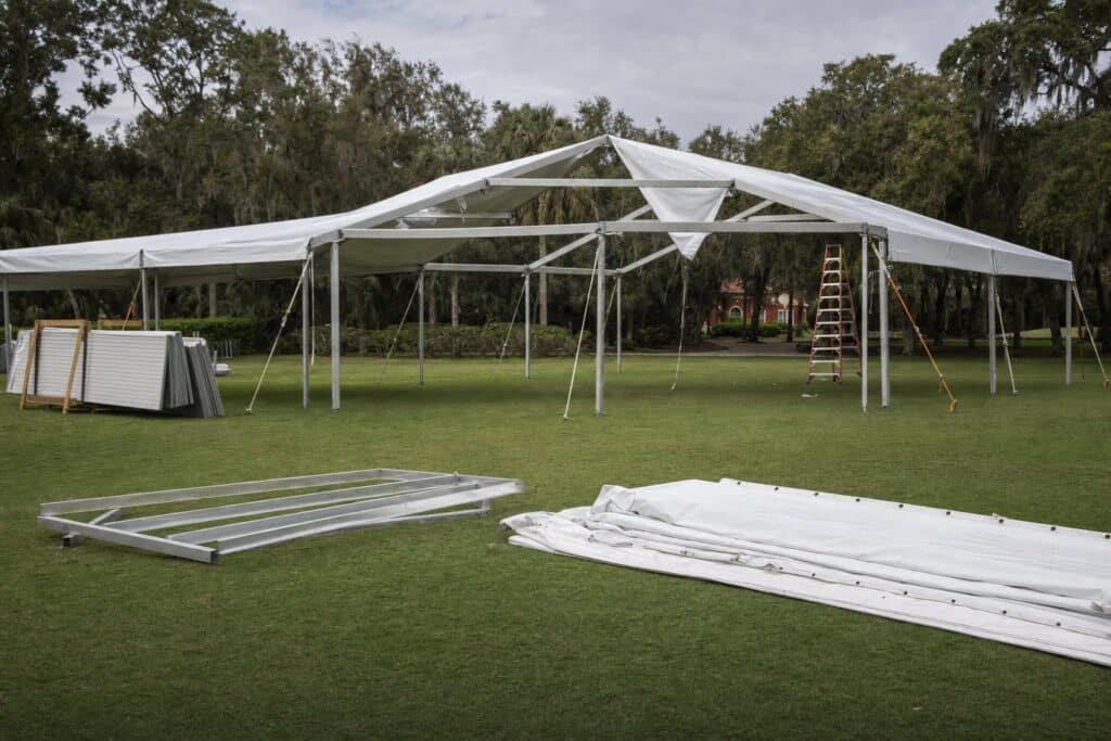 Creative Events & Rentals installing a white frame event tent on a Southwest Florida lawn