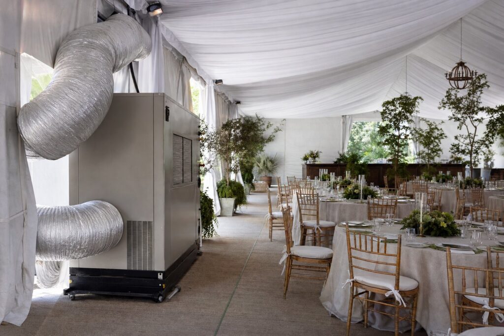 Climate-controlled event tent interior with a portable air-conditioning unit and ducting by Creative Events & Rentals